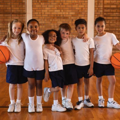 front-view-of-schoolkids-standing-and-looking-at-camera-at-basketball-court-in-school.jpg